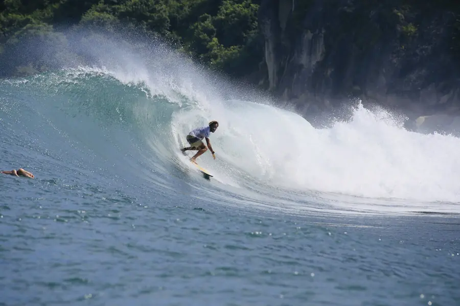 Surfeur dans un tube, forêt tropicale en arrière-plan